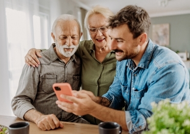 Son showing something on his phone to his parents